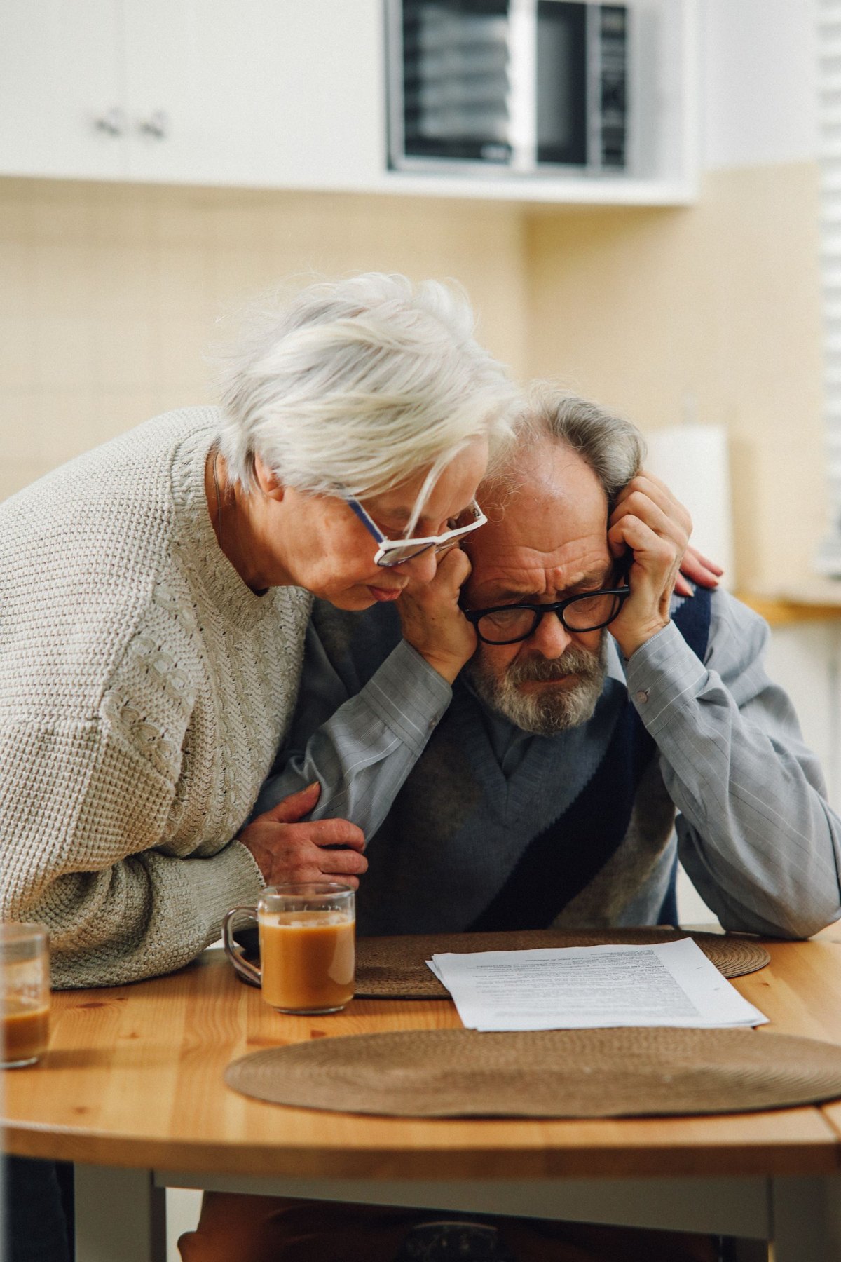 Older couple reviewing paperwork together at a kitchen table