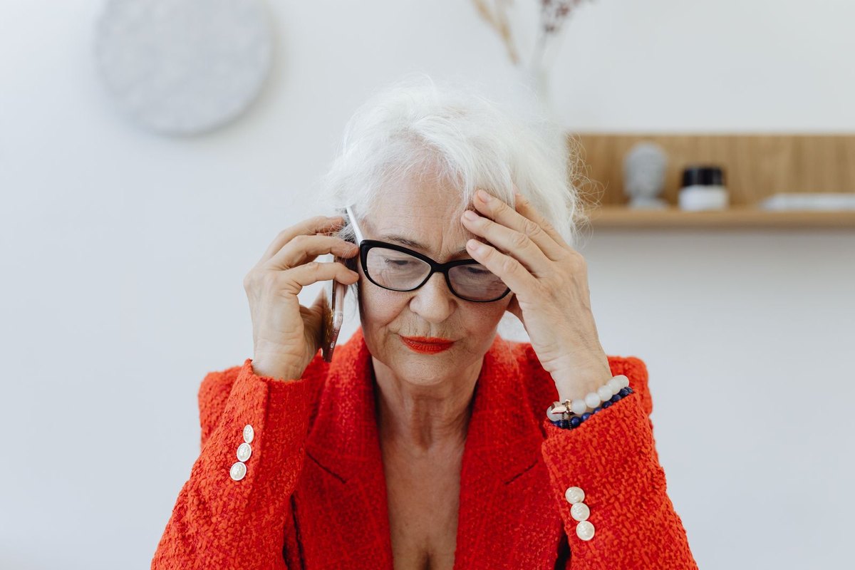 Senior woman looking concerned during a phone call at home