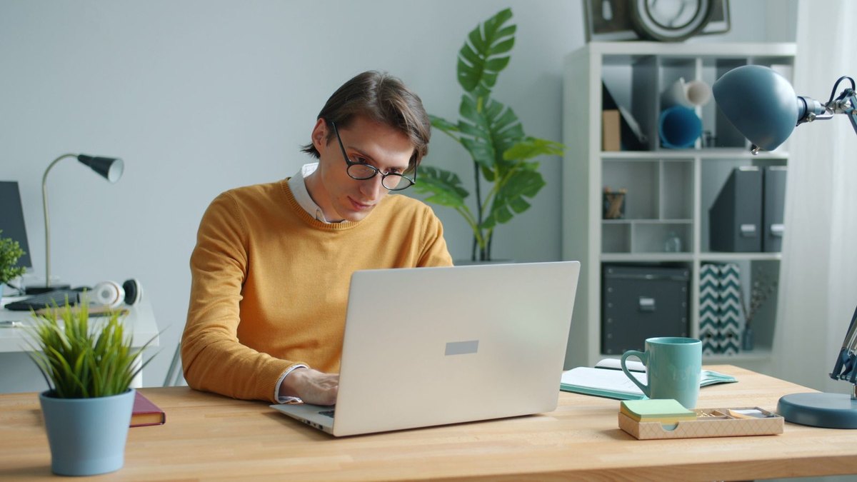 Person working remotely on a laptop in a home office
