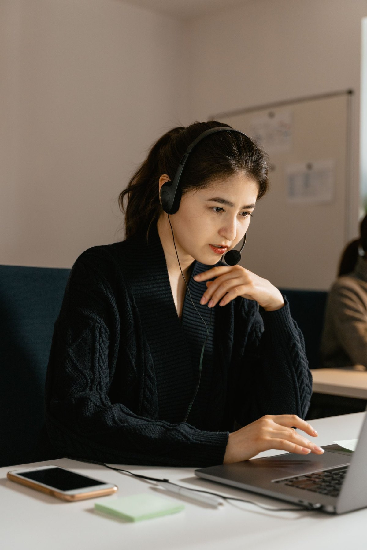 Customer-support agent with headset in front of a laptop