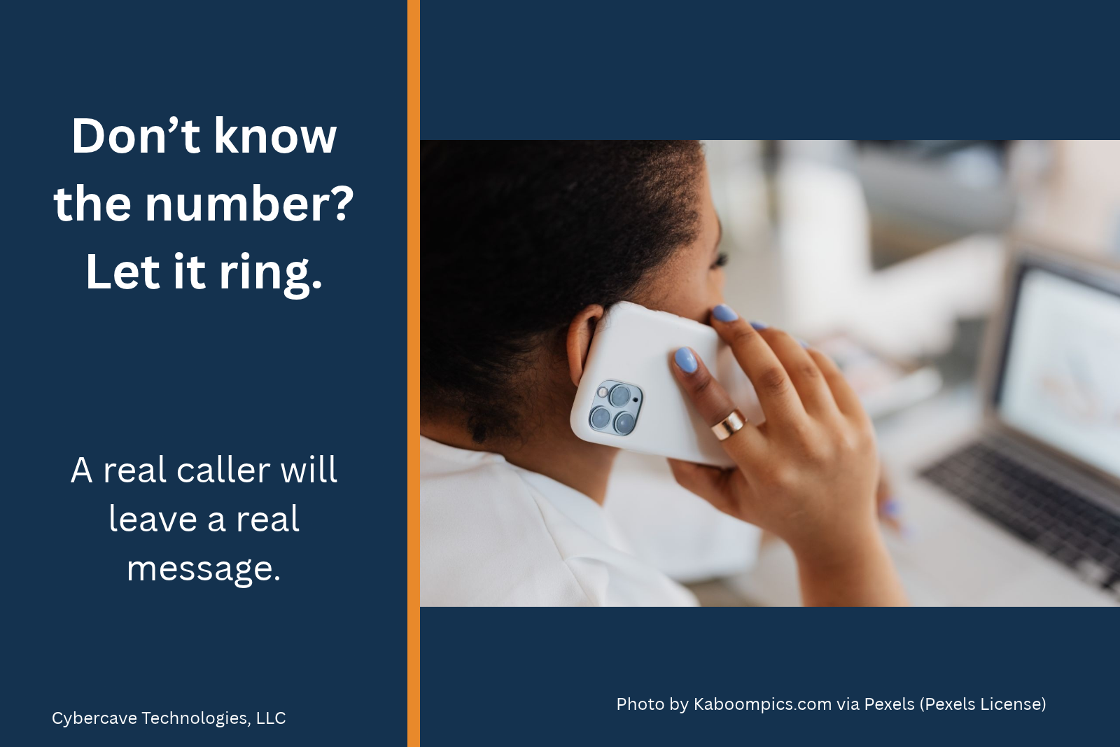 A person holding a phone to their ear at a desk